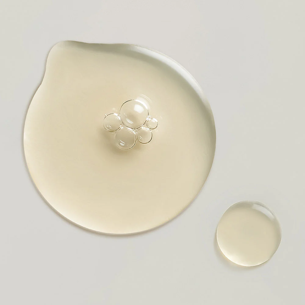 Whamisa Two drops of clear liquid on a light surface | Available at budcosmetics.com